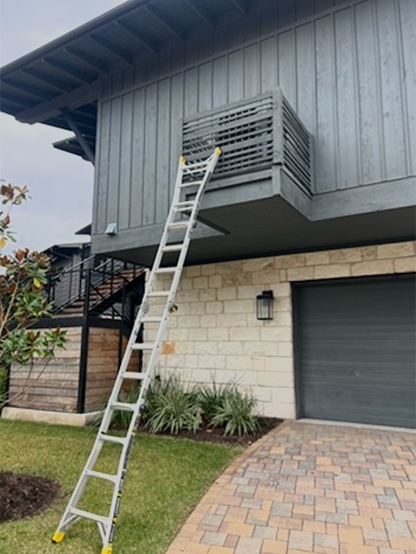 A Climate Mechanical ladder set up to reach a high air handler at an Austin area home